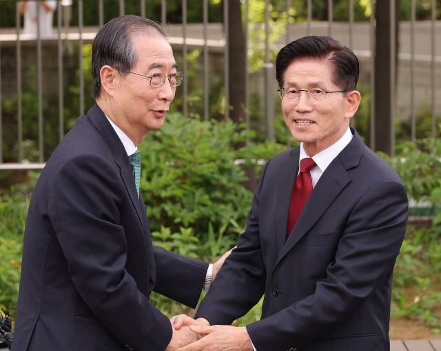 국민의힘 김문수(오른쪽) 대선후보와 무소속 한덕수 대선 예비후보가 8일 서울 국회 사랑재에 위치한 커피숍에서 만나 악수하고 있다. [연합뉴스]